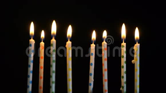 彩色燃烧的蜡烛放在黑色背景上4k视频的预览图