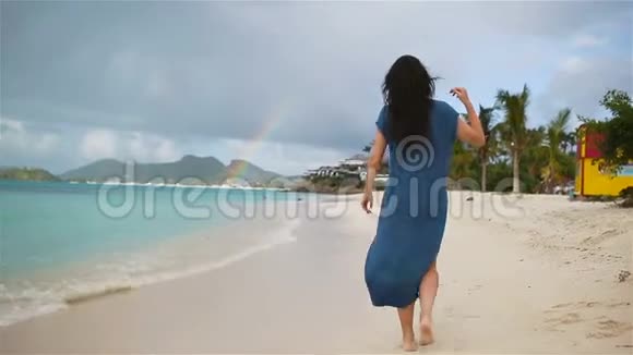 热带海滨的年轻美女快乐女孩在白沙热带海滩放松视频的预览图