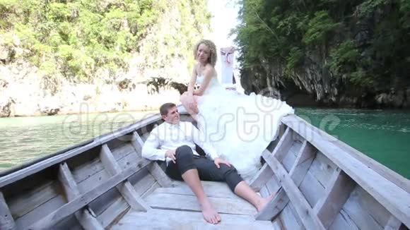 欧洲新娘新郎坐在长尾船上视频的预览图