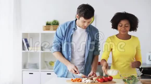 快乐的一对夫妇带着平板电脑在家做饭视频的预览图