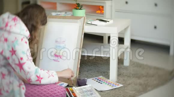 年轻的女画家在家坐在地板上创作绘画视频的预览图