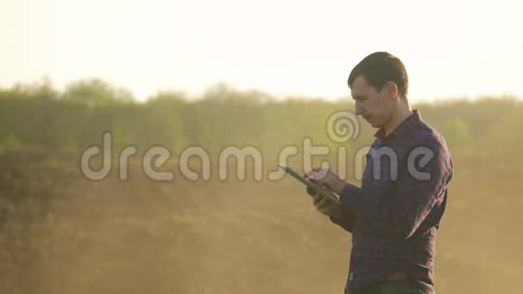 一位年轻貌美的农民学生在田里工作的肖像他的生活方式是拖拉机在平板电脑里工作视频的预览图