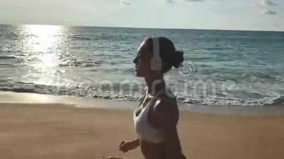 快乐健康的女孩在沙滩上奔跑视频的预览图