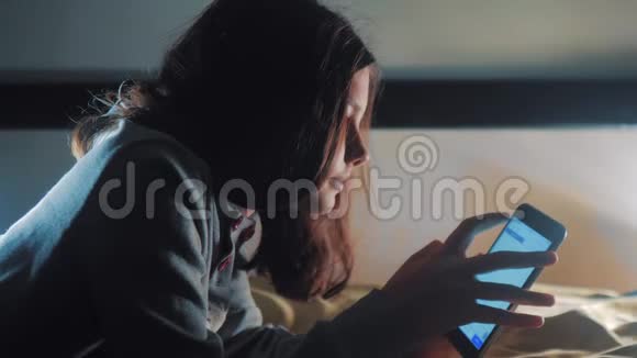 少女和智能手机生活方式一个小少女在社交媒体信使之夜写了一条聊天信息视频的预览图