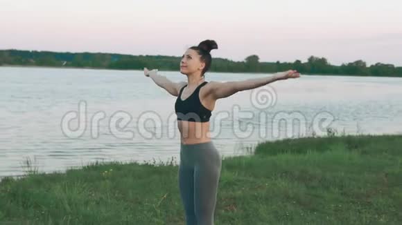早上在湖边做瑜伽的漂亮女孩健康生活方式视频的预览图