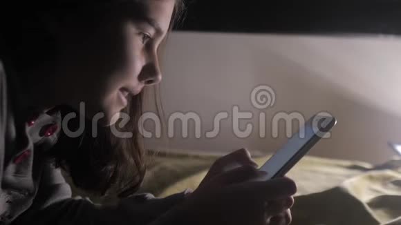 少女和智能手机小青少年帽女孩在生活方式社交媒体信使之夜的聊天留言视频的预览图