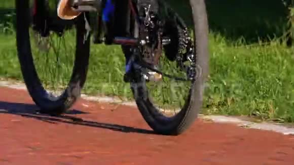 人们骑自行车在公园的自行车车道上慢动作视频的预览图
