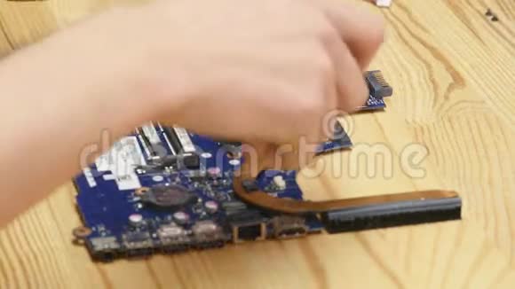 修理工拆卸笔记本电脑主板工程师在工作中修理坏电脑电子修理店技术视频的预览图