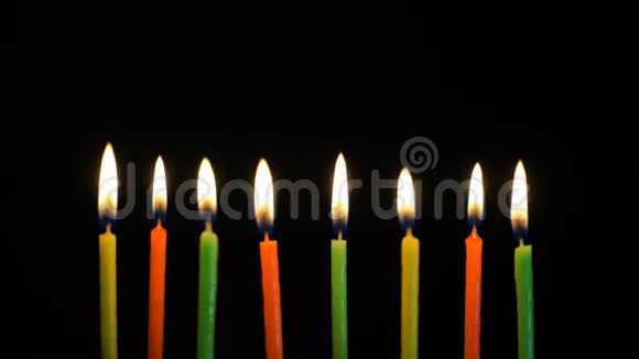 彩色燃烧的蜡烛放在黑色背景上4k视频的预览图
