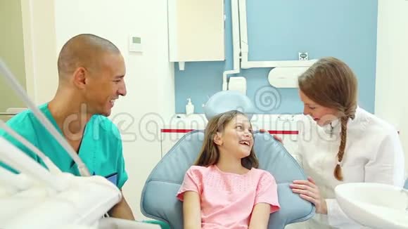 友好的牙医助理和可爱的小病人交谈视频的预览图