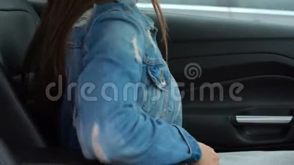 驾驶前坐在车内时女性用手系好汽车安全带视频的预览图