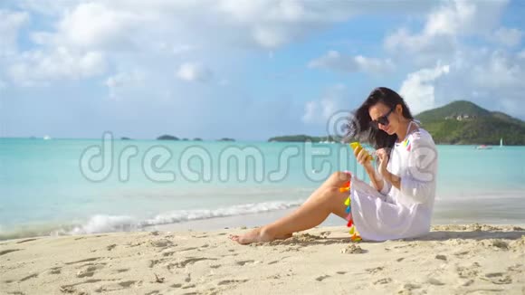 带智能手机的年轻女性在热带海滩度假视频的预览图