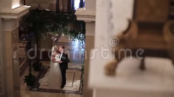 新娘和新郎拥抱在宫殿里视频的预览图