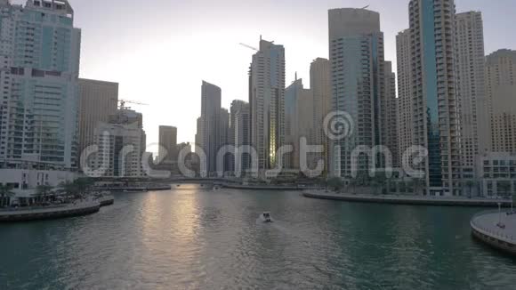 在阿拉伯联合酋长国的玻璃摩天大楼之间的迪拜码头上漂浮的船只视频的预览图