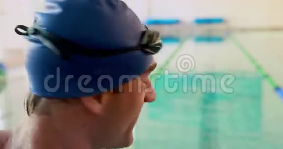 游泳健将对着泳池边的镜头微笑视频的预览图