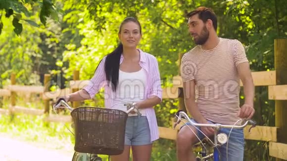 快乐的一对有自行车的情侣在夏天公园聊天视频的预览图