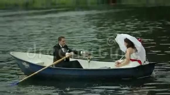 一对新婚夫妇在划艇上视频的预览图