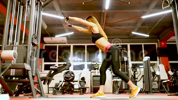 穿运动服装的运动员女孩锻炼和训练她的手臂和肩膀健身房视频的预览图