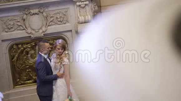 新娘和新郎拥抱在宫殿里视频的预览图