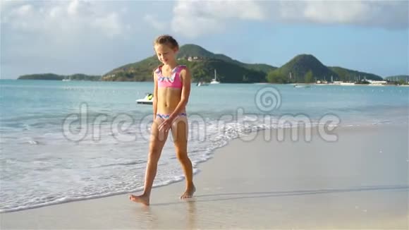 可爱的小女孩在热带海滩玩得开心视频的预览图