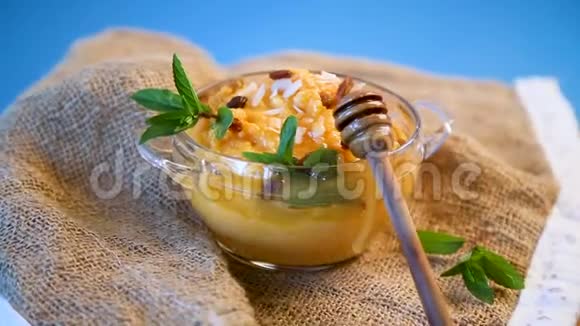 用葡萄干和坚果在玻璃碗里煮甜南瓜粥视频的预览图