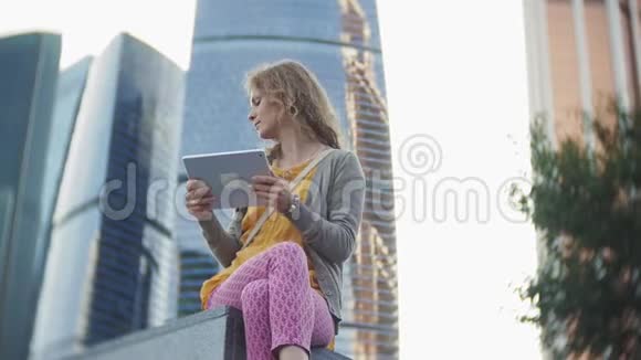 年轻的时髦女人正在城市公园商业中心散步视频的预览图