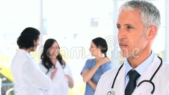 微笑成熟的医生站在他的团队面前视频的预览图