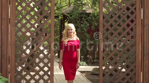 公园里穿红色裙子的优雅女孩的肖像视频的预览图