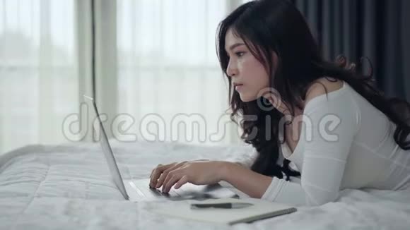 女人在床上用笔记本电脑视频的预览图