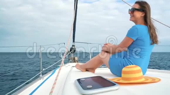 穿着黄色帽子和蓝色衣服的女人在海洋的夏季在游艇上休息视频的预览图