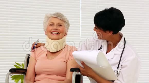护士与坐轮椅的老年病人交谈视频的预览图