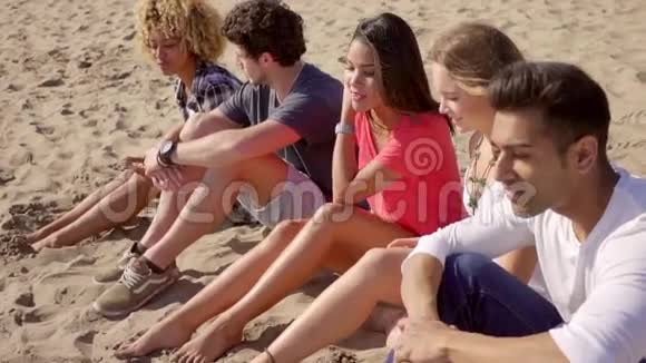 一群坐在沙滩上的年轻人视频的预览图