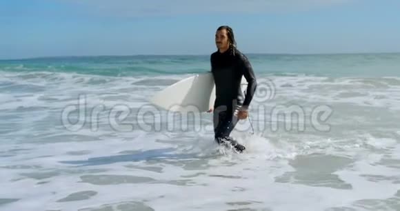 带着冲浪板在海上行走的人视频的预览图