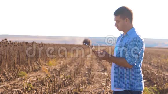 农民的生活方式聪明的农业工人阅读或分析收获向日葵在平板电脑上的农业报告视频的预览图