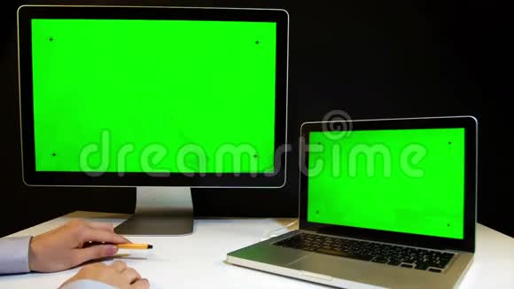 在笔记本电脑上工作并用绿色屏幕显示视频的预览图
