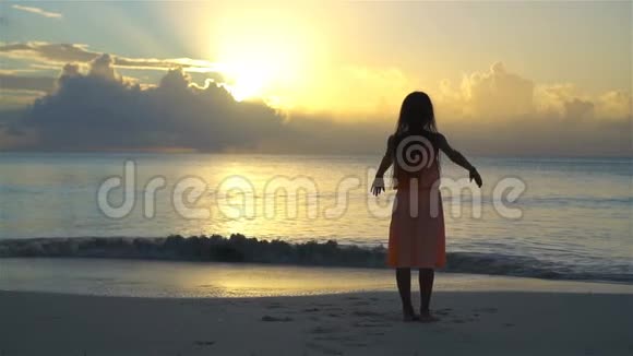 可爱的快乐小女孩在白色海滩日落视频的预览图