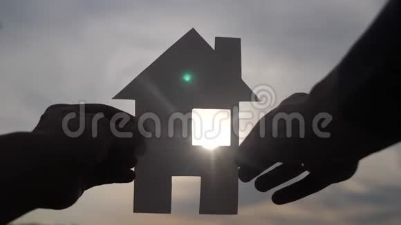 幸福家园建设理念他手里拿着一个纸房生活方式他的手在夕阳下剪影视频的预览图