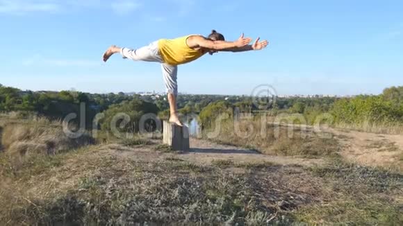 年轻的运动男子站在瑜伽姿势户外在大自然中练习瑜伽动作和姿势的白人运动员视频的预览图