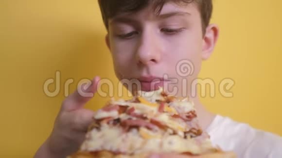 快乐的小男孩吃一片披萨的概念小男孩饿了吃一片披萨生活方式慢动作视频视频的预览图