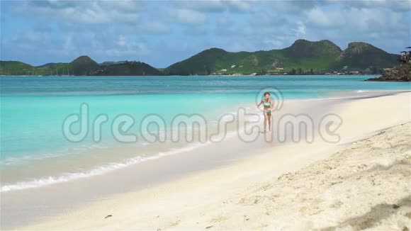 加勒比海岛海滩上可爱的小女孩视频的预览图