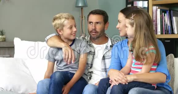 可爱的家人坐在沙发上聊天视频的预览图