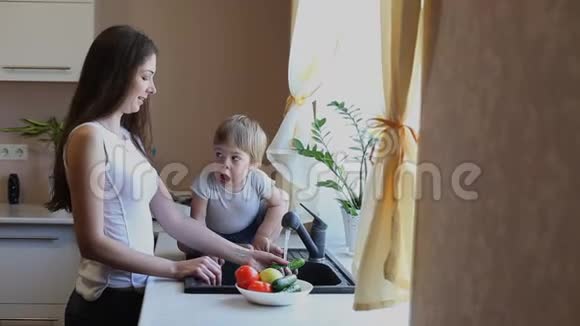 母亲和儿子在厨房洗蔬菜视频的预览图