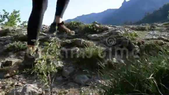 漫步在山顶悬崖峭壁上的旅行妇女徒步旅行在岩石上行走视频的预览图
