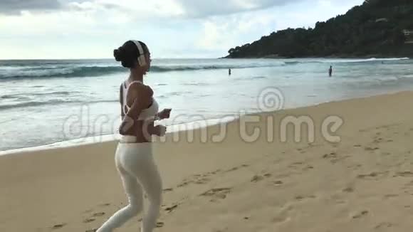 快乐健康的女孩在沙滩上奔跑视频的预览图