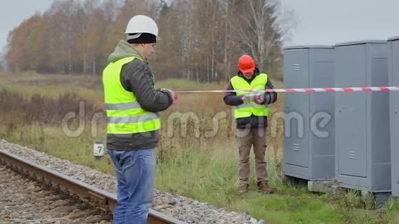 铁路上带警示带的工人视频的预览图