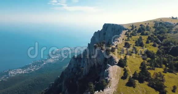 高山峰和大海山谷边缘的史诗岩石和太阳耀斑无人驾驶飞机飞行空中飞行视频的预览图