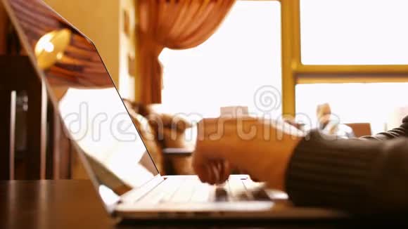 手在咖啡馆的笔记本电脑键盘上打字视频的预览图