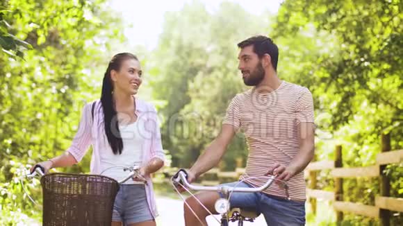 快乐的一对有自行车的情侣在夏天公园聊天视频的预览图
