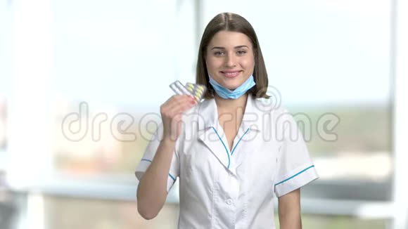 年轻的女医生拿着药丸视频的预览图