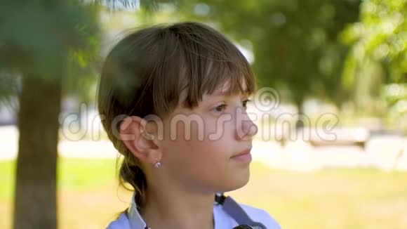 戴着耳机的女孩在夏天公园微笑视频的预览图
